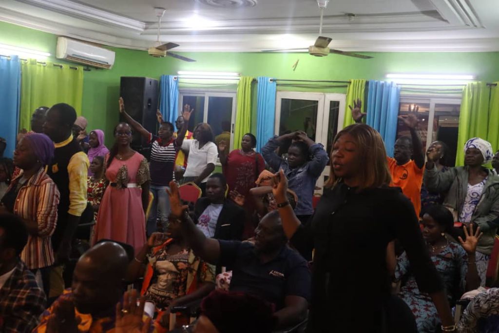 MCC Ouaga - Assemblée debout en louange mains levées